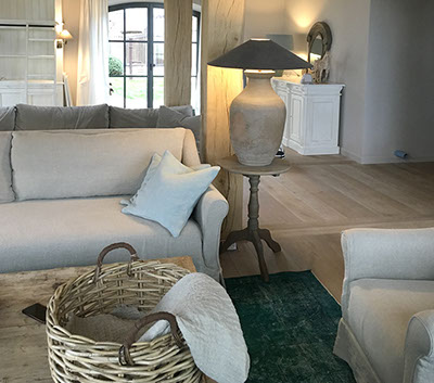 Innenrichtung auf der Insel Sylt. Runder Küchentisch aus Eiche mit edlen Sesseln aus rattan.