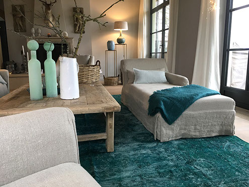 Innenrichtung auf der Insel Sylt. Runder Küchentisch aus Eiche mit edlen Sesseln aus rattan.