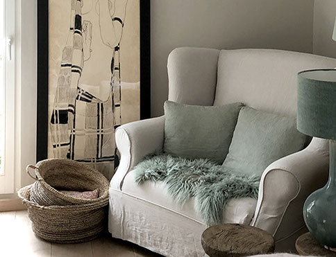 Innenrichtung auf der Insel Sylt. Runder Küchentisch aus Eiche mit edlen Sesseln aus rattan.