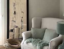 Innenrichtung auf der Insel Sylt. Runder Küchentisch aus Eiche mit edlen Sesseln aus rattan.