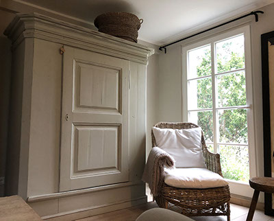 Innenrichtung auf der Insel Sylt. Runder Küchentisch aus Eiche mit edlen Sesseln aus rattan.