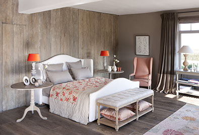 Die orangenen Lampenschirm setzten Akzente an den richtigen Stellen und werden durch Plaid, Kissen und Sessel gestützt.