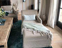 Innenrichtung auf der Insel Sylt. Runder Küchentisch aus Eiche mit edlen Sesseln aus rattan.