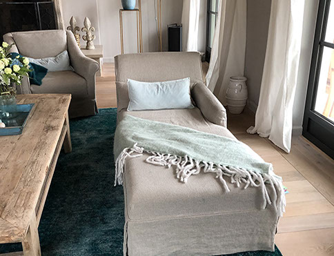 Innenrichtung auf der Insel Sylt. Runder Küchentisch aus Eiche mit edlen Sesseln aus rattan.