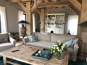 Innenrichtung auf der Insel Sylt. Runder Küchentisch aus Eiche mit edlen Sesseln aus rattan.