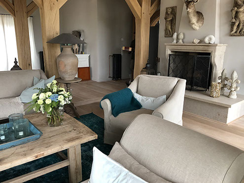 Innenrichtung auf der Insel Sylt. Runder Küchentisch aus Eiche mit edlen Sesseln aus rattan.